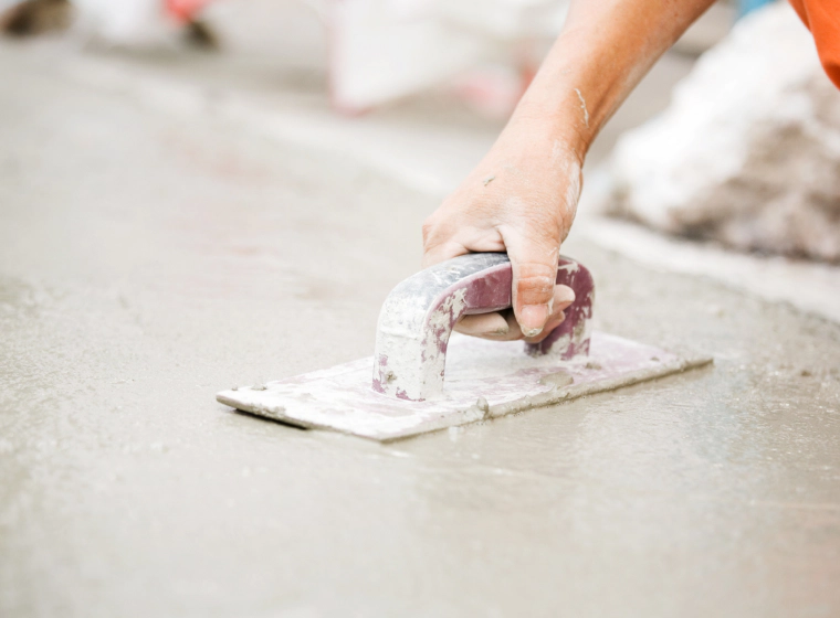 worker flattening a concrete floor